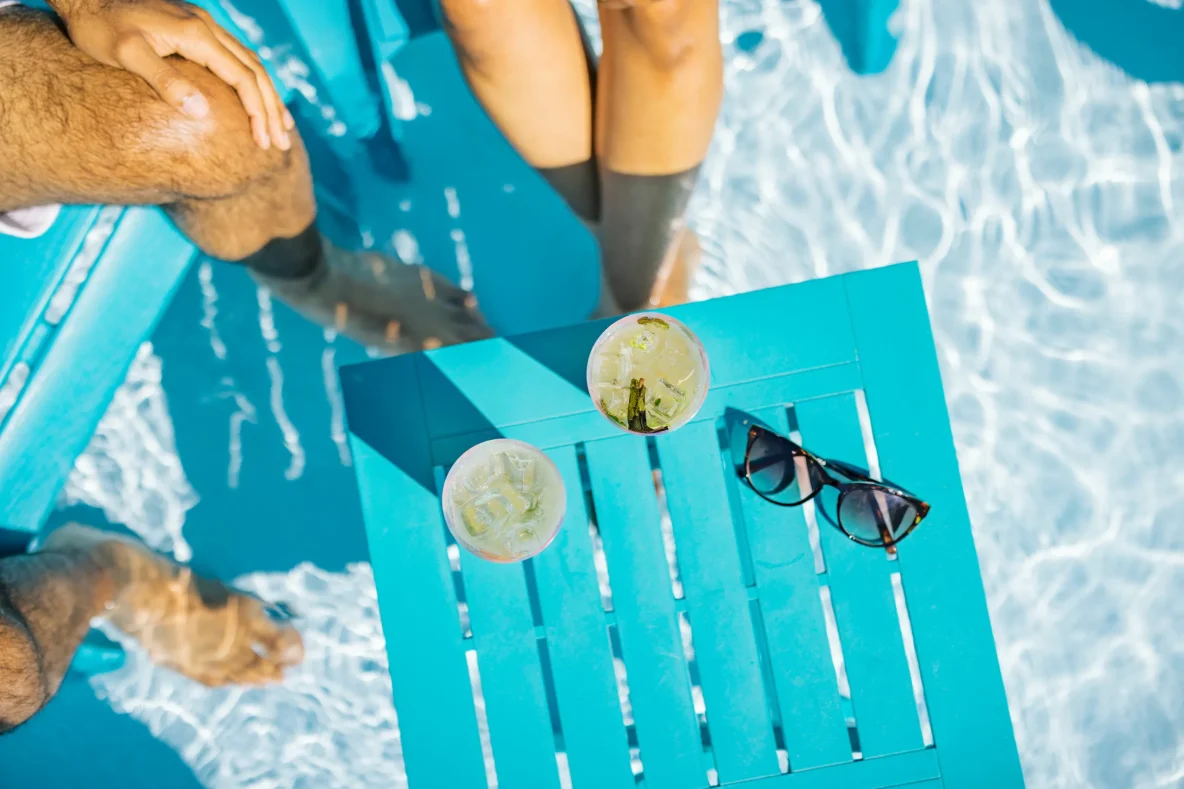 Image de gens ayant les pieds dans l'eau et savourant des breuvages