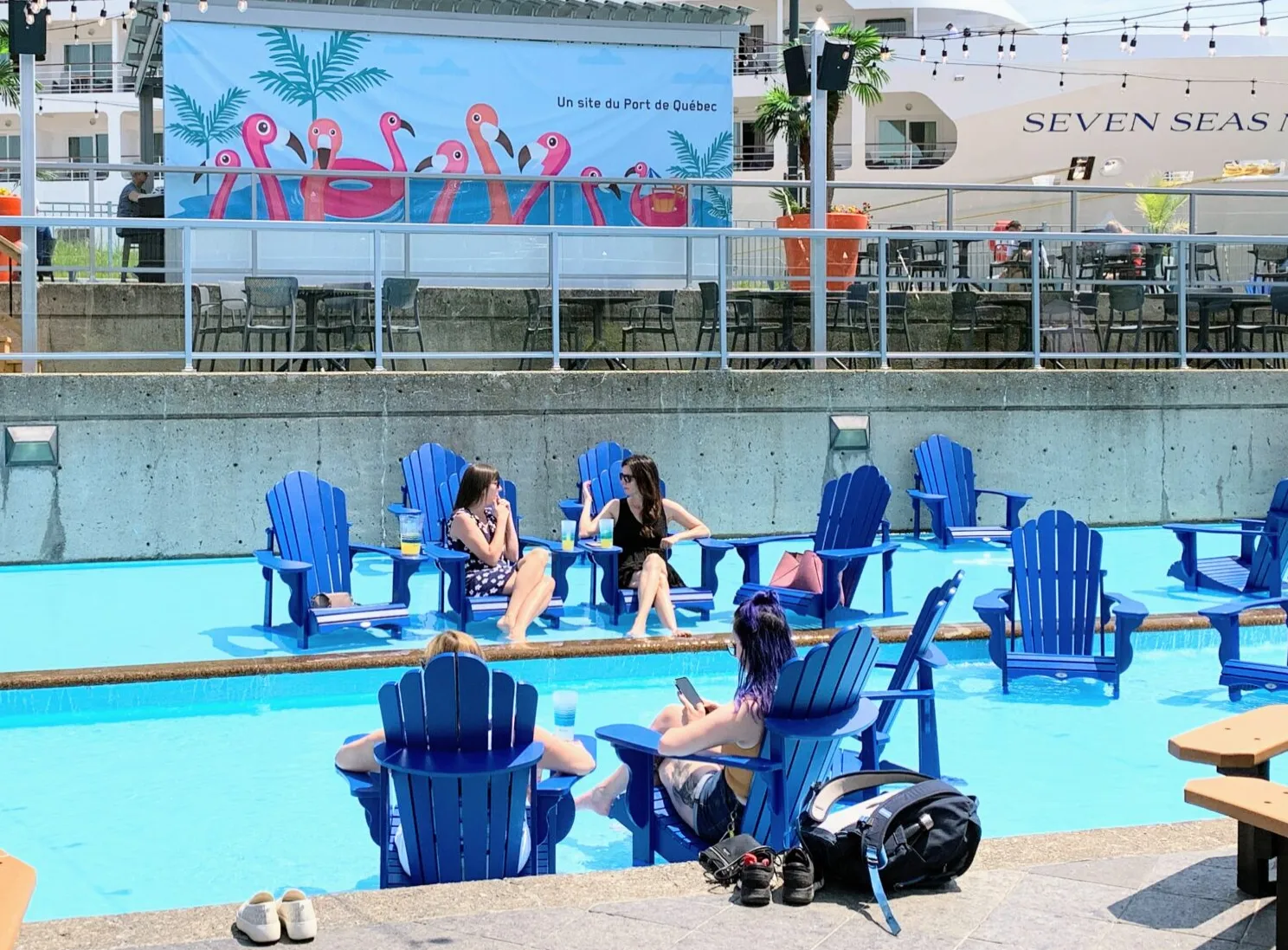 Image de gens assied sur de chaise avec les pieds dans une piscine